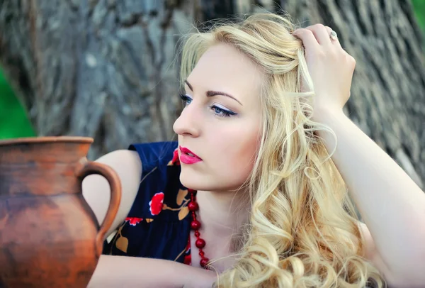 Retrato de una hermosa mujer rubia con una jarra de cerámica — Foto de Stock