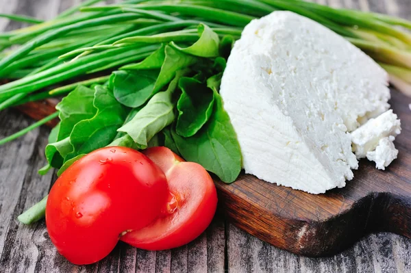 Cheese with tomatoes and arugula and onion — Stock Photo, Image