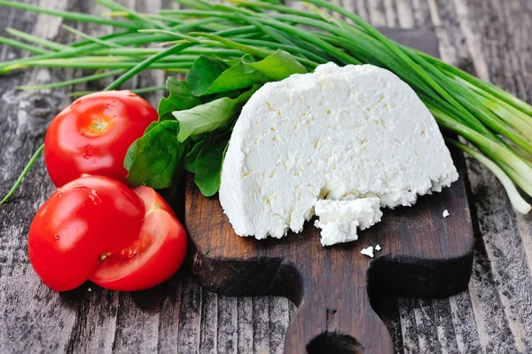 Ahşap tahta üzerine soğan ve roka ve domates ile peynir — Stok fotoğraf