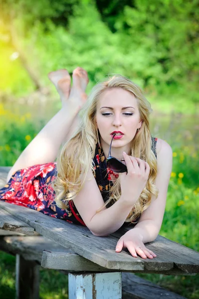 Beautiful girl lying in summer grass — Stock Photo, Image