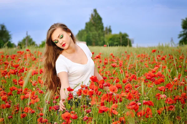 Giovane bella ragazza in un campo di papaveri — Foto Stock