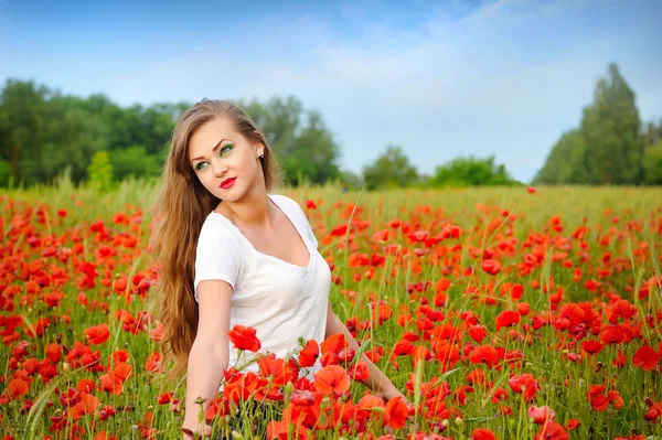 Giovane bella ragazza in un campo di papaveri — Foto Stock