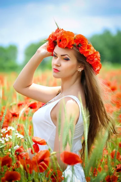 Schöne junge Frau in rot leuchtendem Mohnfeld. Sommerporträt — Stockfoto