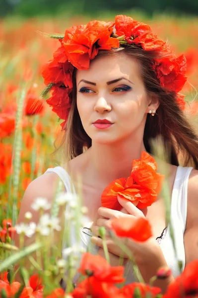 Schöne junge Frau in rot leuchtendem Mohnfeld. Sommerporträt — Stockfoto