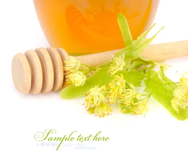 Vaso di miele fresco con fiori di tiglio su sfondo bianco — Foto Stock