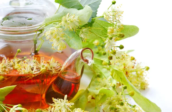 Teapot with linden tea and flowers, close-up — Stock Photo, Image