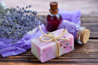 Ahşap masadaki lavanta spa ürünleri. Lavantalı vücut bakım ürünleri: sabun, yağ, tuz ve kurutulmuş lavanta çiçekleri. Seçici odak.