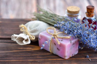 Ahşap masadaki lavanta spa ürünleri. Lavantalı vücut bakım ürünleri: sabun, yağ, tuz ve kurutulmuş lavanta çiçekleri. Seçici odak.