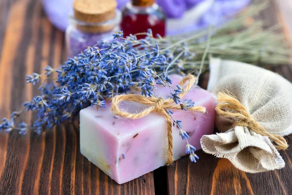 Ahşap masadaki lavanta spa ürünleri. Lavantalı vücut bakım ürünleri: sabun, yağ, tuz ve kurutulmuş lavanta çiçekleri. Seçici odak.