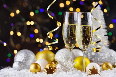 İki şampanya bardağı ve karla süslenmiş Noel süslemeleri. Mutlu yıllar..