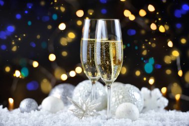 İki şampanya bardağı ve karla süslenmiş Noel süslemeleri. Mutlu yıllar..