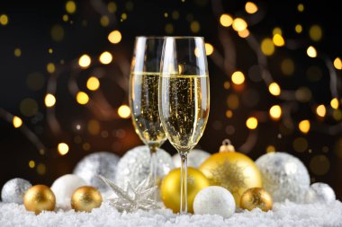 İki şampanya bardağı ve karla süslenmiş Noel süslemeleri. Mutlu yıllar..