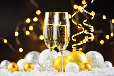 İki şampanya bardağı ve karla süslenmiş Noel süslemeleri. Mutlu yıllar..