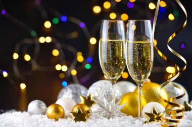 İki şampanya bardağı ve karla süslenmiş Noel süslemeleri. Mutlu yıllar..