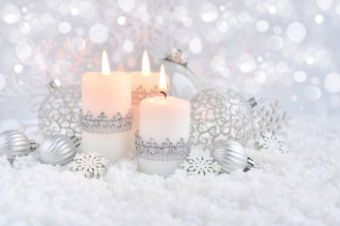 Noel kompozisyonu. Karda süslü balolar ve mumlar var. Noel veya Yeni Yıl tebrik kartı.