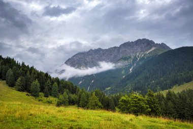 Summer mountain landscape with thunderstorm clouds. Location place Alps, Europe.