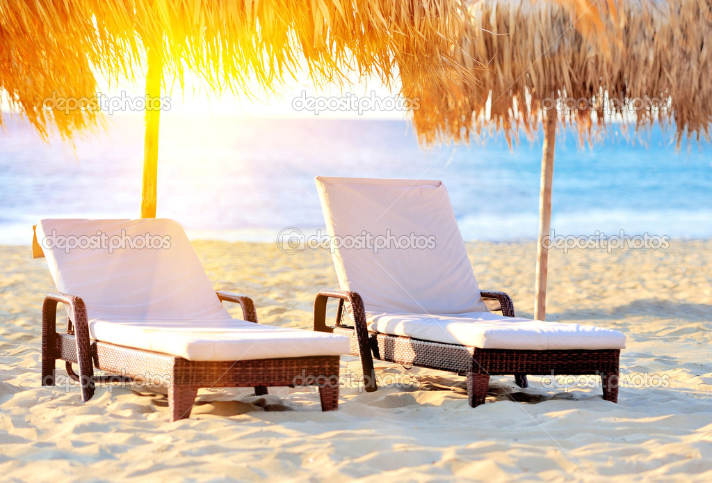 Two beach chairs with white umbrella
