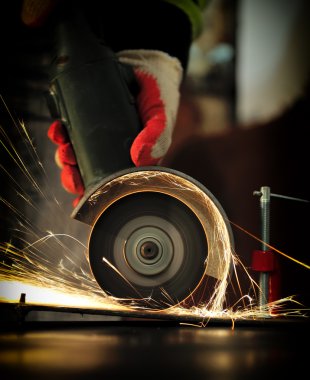 Worker cutting metal with grinder clipart