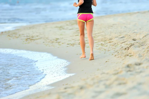 Kör ben och skor av löpare jogging på stranden — Stockfoto