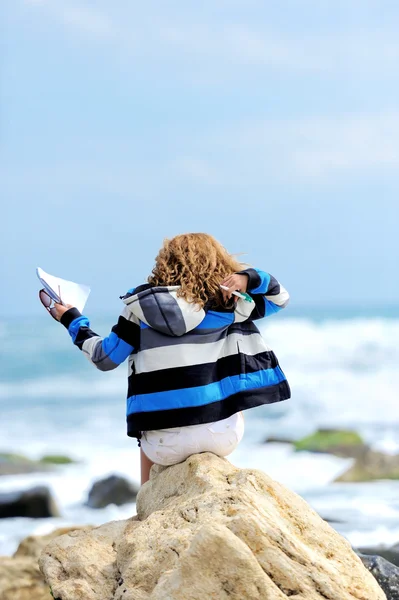 Beautiful young woman sitting on the stone — Stock Photo, Image