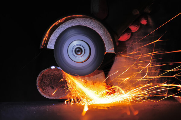 Worker cutting metal with grinder