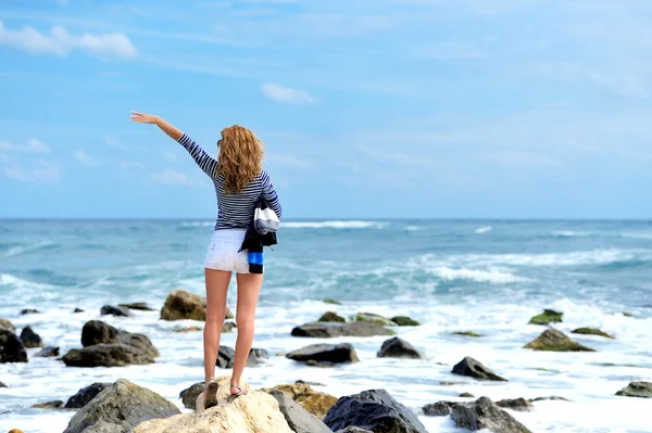 Mujer en la piedra en la orilla del mar —  Fotos de Stock