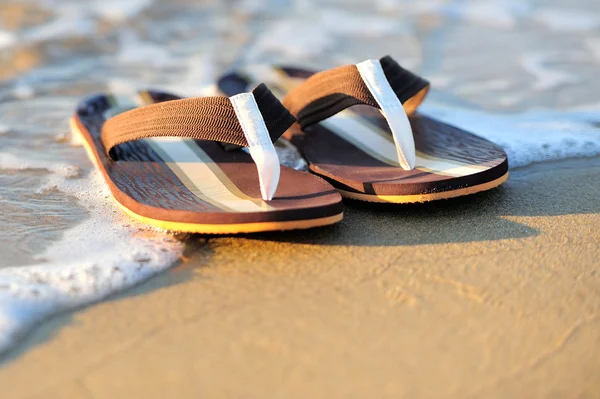 Klapki japonki na plaży piaszczysta oceanu — Zdjęcie stockowe