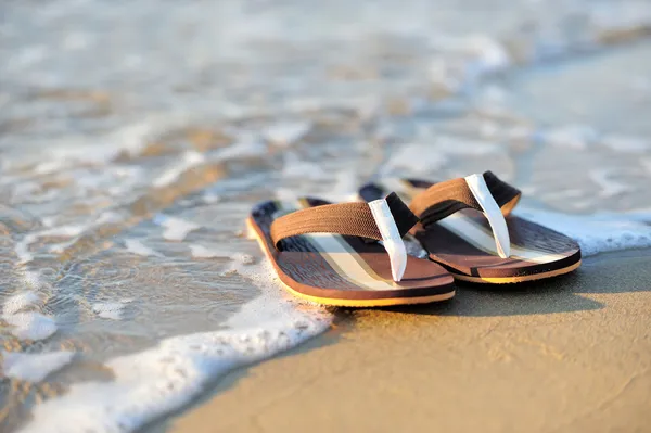 Klapki japonki na plaży piaszczysta oceanu — Zdjęcie stockowe