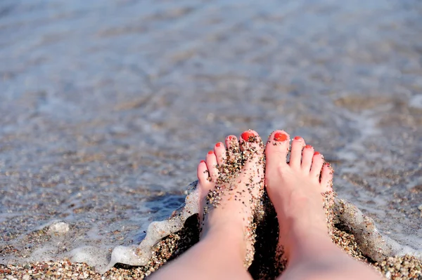 Kvinna fötter närbild av flicka avkopplande på stranden — Stockfoto