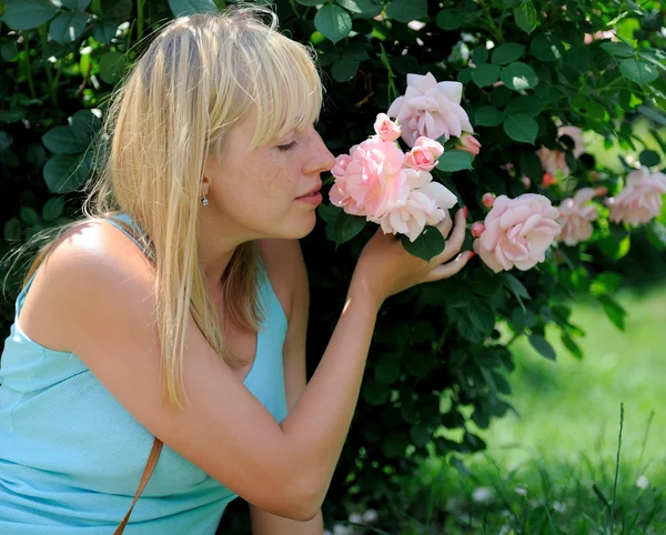 Kvinna i trädgård med rosor — Stockfoto