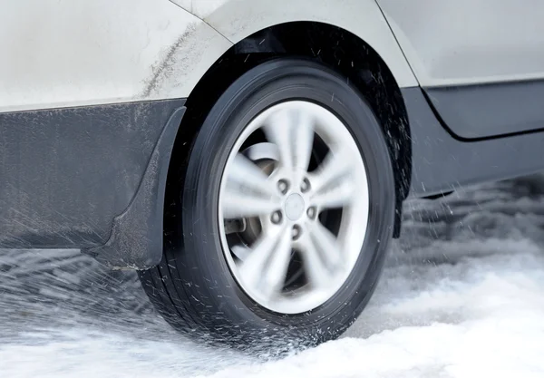 Dirty car wheel stands on winter road — Stock Photo, Image