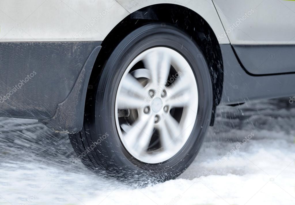 Dirty car wheel stands on winter road