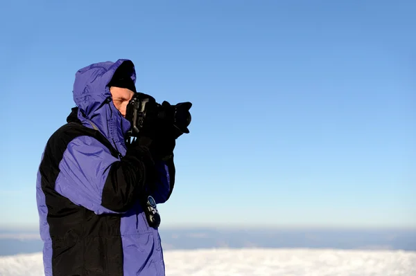 Fotograaf in winter mountain — Stockfoto