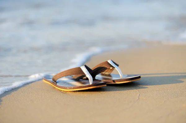 Flip flops on a sandy ocean beach — Stock Photo, Image