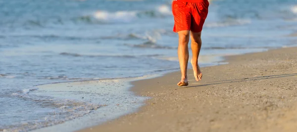 Benen voor runner waarop strand — Stockfoto