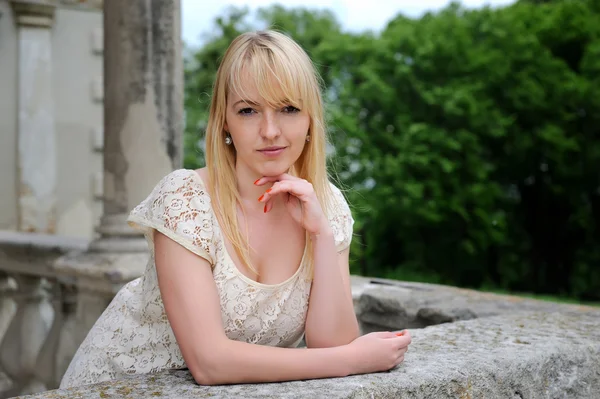 Schönes junges Mädchen steht auf dem steinernen Balkon — Stockfoto