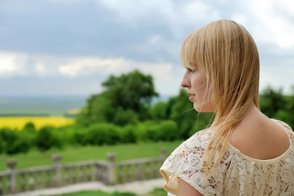 Piękna, młoda dziewczyna stoi na balkon kamienia — Zdjęcie stockowe