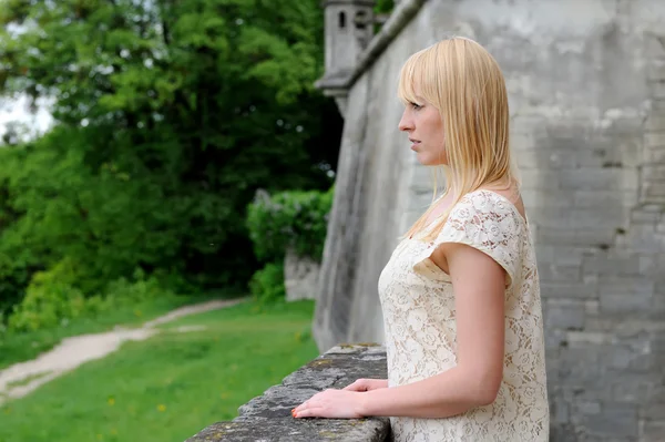 Beautiful young girl standing on the stone balcony — Stock Photo, Image