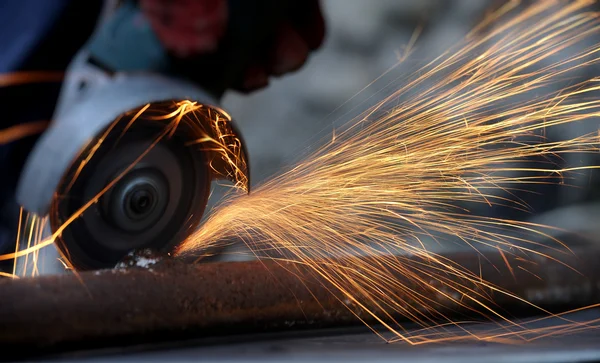 Worker cutting metal with grinder — Stock Photo, Image