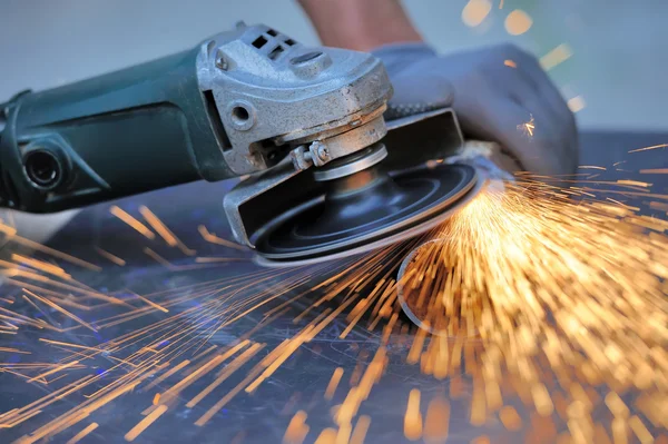 Worker cutting metal with grinder — Stock Photo, Image