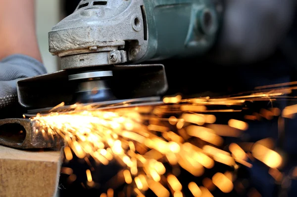 Worker cutting metal with grinder — Stock Photo, Image