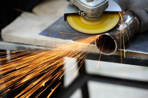 Worker cutting metal with grinder — Stock Photo, Image