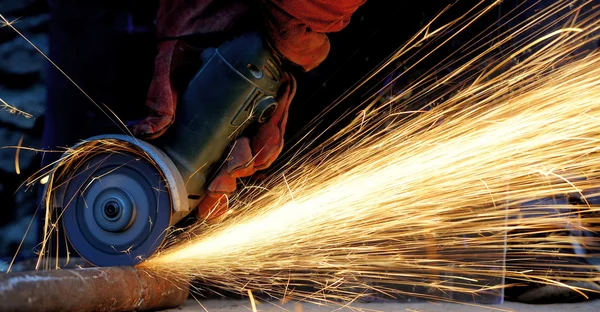 Worker cutting metal with grinder — Stock Photo, Image