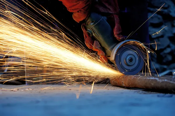Worker cutting metal with grinder — Stock Photo, Image