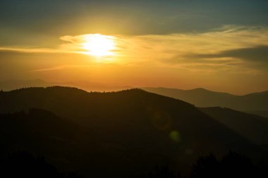 Güneşli ışıklarla dağlarda görkemli günbatımı