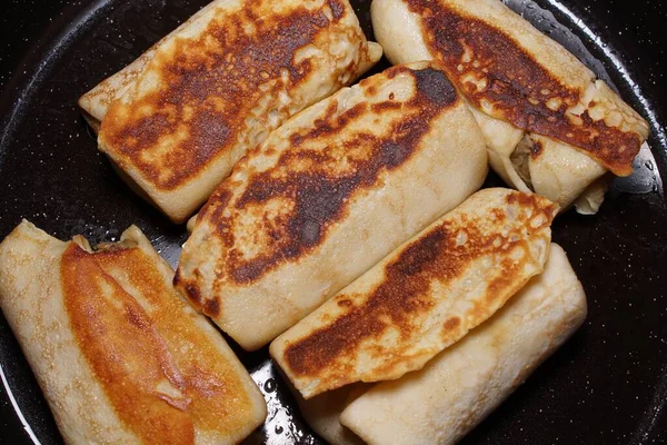 Lahana ve mantarla doldurulmuş gözlemeler, tavada kızartılıyor.