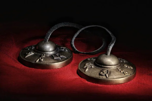 Siyah bir arka planda kırmızı bir kumaş üzerinde uzanan vajina ve Tingsha ve ghanta Tibet meditasyon çanları