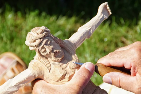 木彫りのイエスの姿を彫る民俗彫刻家の手 — ストック写真