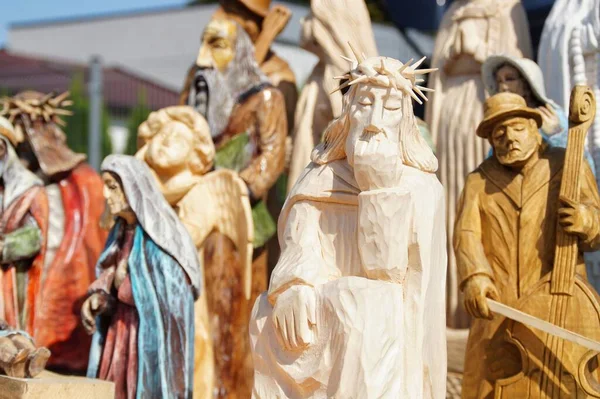 Düşünceli İsa 'nın ahşap figürü diğer halk heykellerinin arka planında bir tezgahta duruyor.