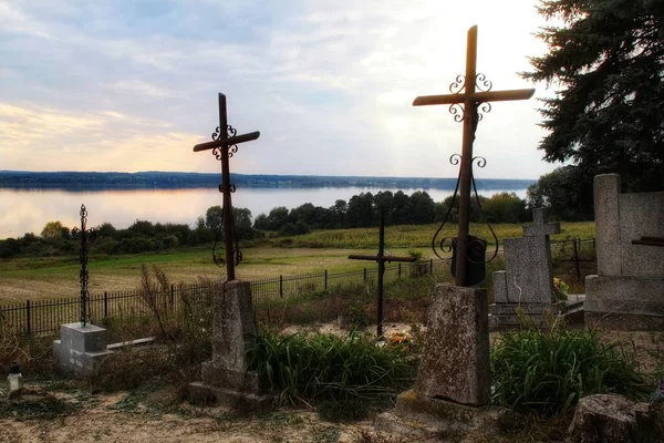 Cemetery crosses against the background of the Vistula River and the sky at the village cemetery in Rokicie on the hill.